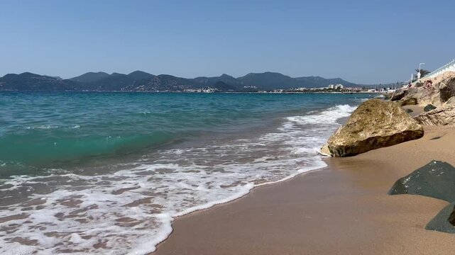 View of the Bay of Cannes with red rocks of Cap Esterel, Cannes, Cte d Azur, France. Cannes beach - France, Provence-Alpes-Cote d'Azur, View from beach to yachts in the evening. View of sea