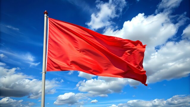Vibrant thin red flag waving gently in the wind against a clear blue sky with a few wispy white clouds, symbolizing courage, patriotism, or celebration.