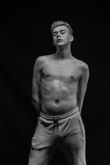 Fototapeta premium Young man posing in the dark in the studio