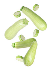 Fresh raw zucchinis falling on white background, whole and slices