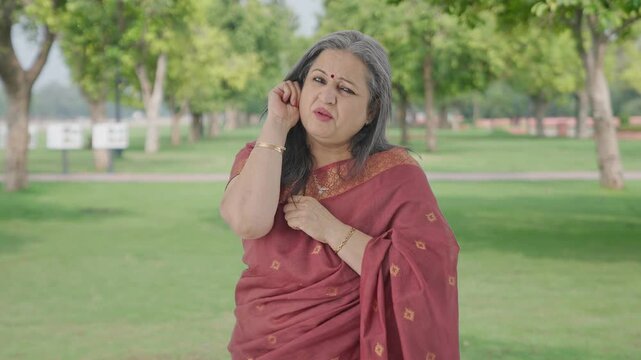Guilty Indian old woman apologizing and saying sorry in park