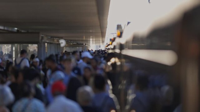 Crowd walking under bridge in slow motion