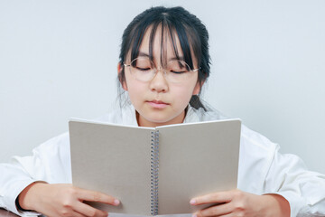 ノートを読み返している眼鏡女子のアップ