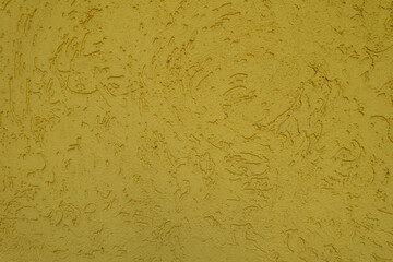 Surface of yellow wall with stucco worm finish