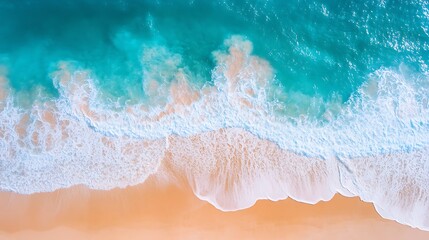 Top-down view of waves crashing on a sandy beach.