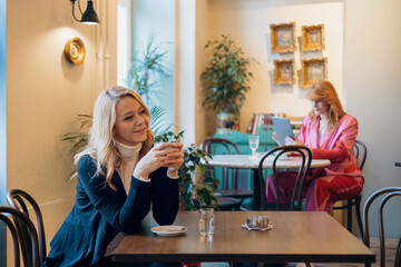 Blonde woman drinking coffee in restaurant
