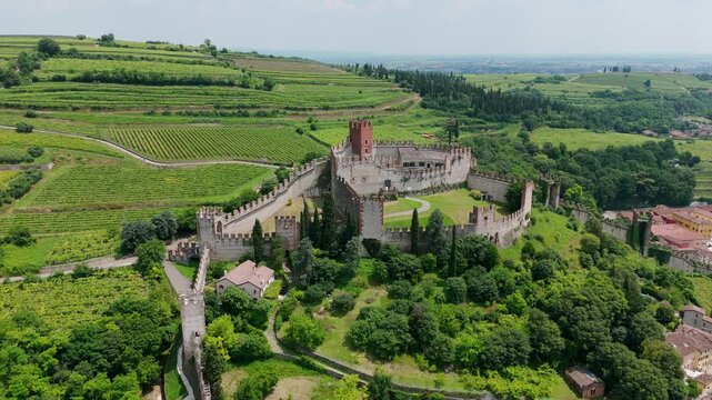 Scaligeri Castle of Soave village, Veneto in Italy. Aerial drone orbiting and panoramic view of vineyards