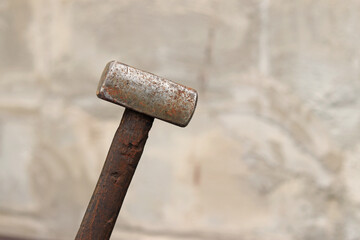 Sledgehammer on a blurred background. Close-up of a two-handed heavy hammer. Hand tools for repair and construction. Close-up of a sledgehammer for repair work