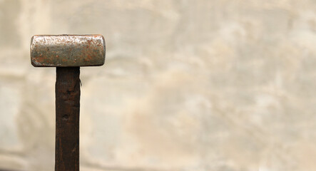 Sledgehammer on a blurred background. Close-up of a two-handed heavy hammer. Hand tools for repair and construction. Close-up of a sledgehammer for repair work