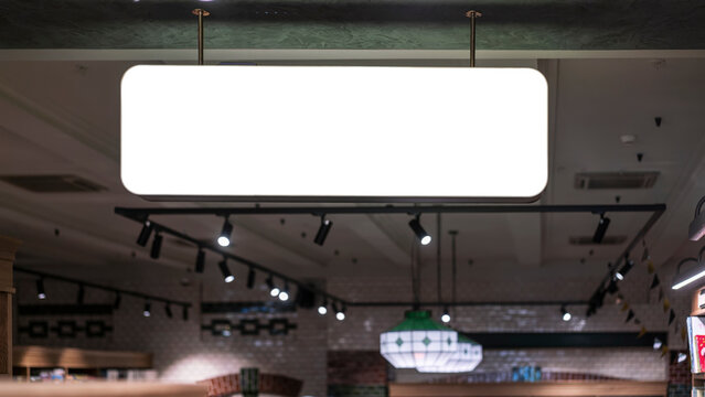 Blank rectangular sign with white space for mockup information hanging from ceiling inside modern retail store