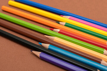 Fototapeta premium Colored pencils on brown background 