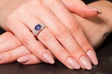 Macro shot of a jewel ring on a female hand.
