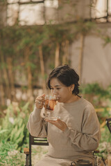 Asian woman drinking tea in the garden at night 