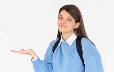 Hey look. Smiling pretty female model pointing at left at empty space and inviting to check it out, showing advertisement on white background.