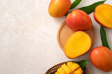 Fresh slice cut juicy mango on gray table background with leaf.