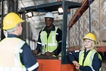 Warehouse worker working in warehouse. Male and female worker discussing at warehouse