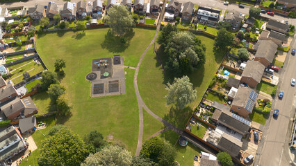 An aerial photograph looking down on a park with a small children's play area set amongst lowrise housing