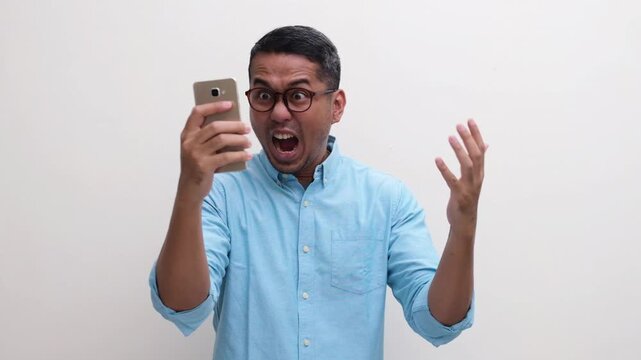 A man showing angry and frustrated when looking to his mobile phone