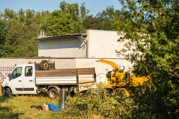 Truck and wood chipper in a backyard on a summer sunny day