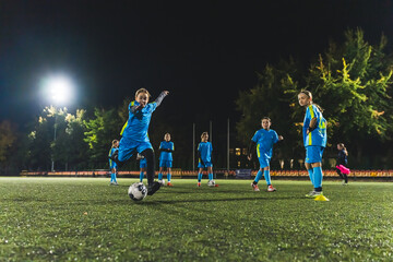 young football player girls practicing in scoring a goal at the evening practice, girls team. High quality photo
