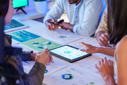 diversity team discusstion about esg and eco friendly system planning in sustainable green office at night