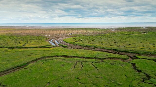 Cracked mud flats in a salt marsh. Aerial: Tidal mudflats, Abstract textures in a cracked coastline, Salt marshes at low tide exposing mud flats and streams at Freiston Shore Lincolnshire UK