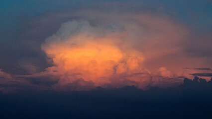 The clouds at dusk, with a dark blue sky tinged with an orange halo.