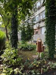Girl scarecrow at the urban city garden 