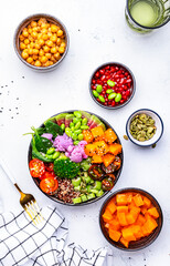 Vegan buddha bowl for balanced diet with sweet potato, quinoa, tomatoes, spinach, celery, edamame, tofu, broccoli and seeds, white background, top view
