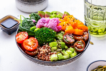 Vegan buddha bowl for balanced diet with sweet potato, quinoa, tomatoes, spinach, celery, edamame, tofu, broccoli and seeds, white background, top view