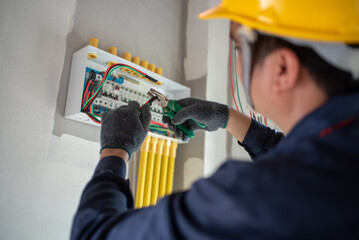 An electrician is wiring the house Electrician Working on Electrical Wiring in a New Construction
