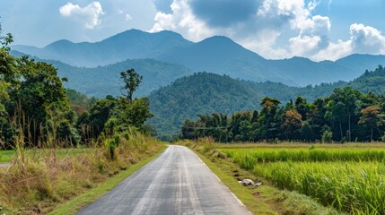 Fototapeta premium Scenic View of Asphalt Road Square Surrounded by Green Mountains and Clouds under a Clear Sky, Depicting Natural Serenity and Open Landscape
