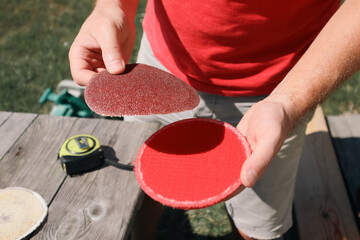 Polishing wood. A carpenter changes a sanding wheel on a grinding machine. Carpenter working in...