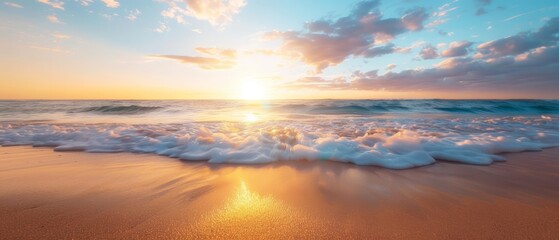  The sun sets over the ocean, waves approach the shore, foreground features a beach