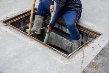 A man is carrying a suction hose from the Waste Water Treatment Plant to the suction truck.