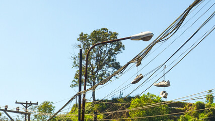 unique, a pair of white shoes hanging on the street electricity cable