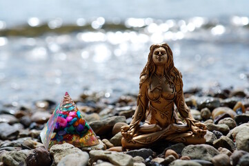 A female Buddha figure on the background of a river.