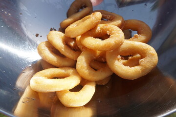 Calamari rings in deep frying in pan. Close up of frying onion rings in the fryer in hot oil.