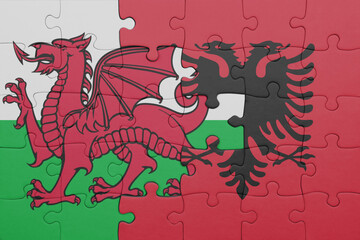 puzzle with the colourful national flag of albania and flag of wales .