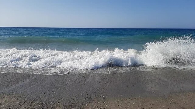 zeitrafferaufnahmen von sch&auml;umenden Wellen, die 2023 mit dem L&auml;rm einer sandigen K&uuml;ste auf der Insel Kreta in Griechenland zusammenbrechen