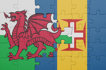 puzzle with the colourful national flag of madeira and flag of wales .