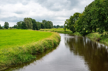 Part of the Wümme river reflecting green nature, Fischerhude, Lower Saxony, Germany