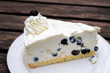Cheescake with blueberry decoration on a worn wooden table, Fischerhude, Lower Saxony, Germany