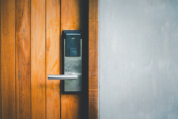 smart digital door lock on closed wooden door with grey concrete wall , lifestyle concepts