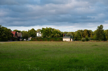 Obraz premium Green fields and houses at the German countryside in Heidenau, Lower Saxony, Germany