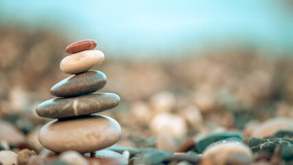 A pyramid of stones on a pebble beach by the sea, the concept of balance, calm, tranquility, relaxation with copy space