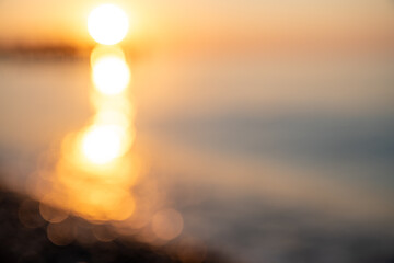 blurred background, sunset or sunrise on the sea, a path of light on the water, highlights and...