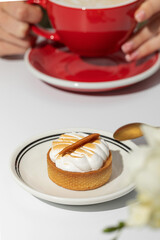 Small meringue cake and coffee cup on white background