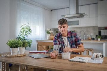 one teenager caucasian man measure check blood pressure at home alone