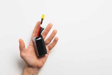 A lithium polymer battery lies on the male hand of a Caucasian man. On a white background. Copy...